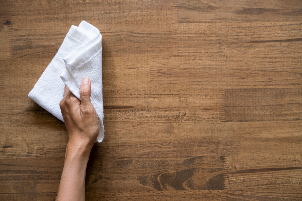 Cleaning table by woman hand